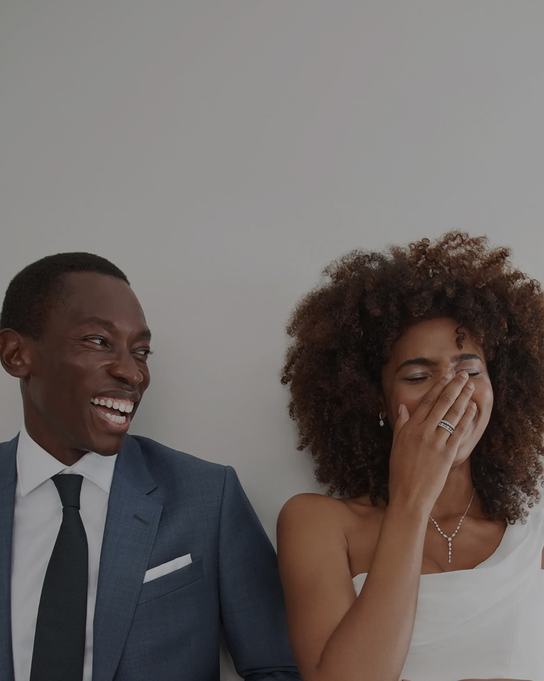 Bride and groom laughing while decked out in beautiful jewelry from KAY