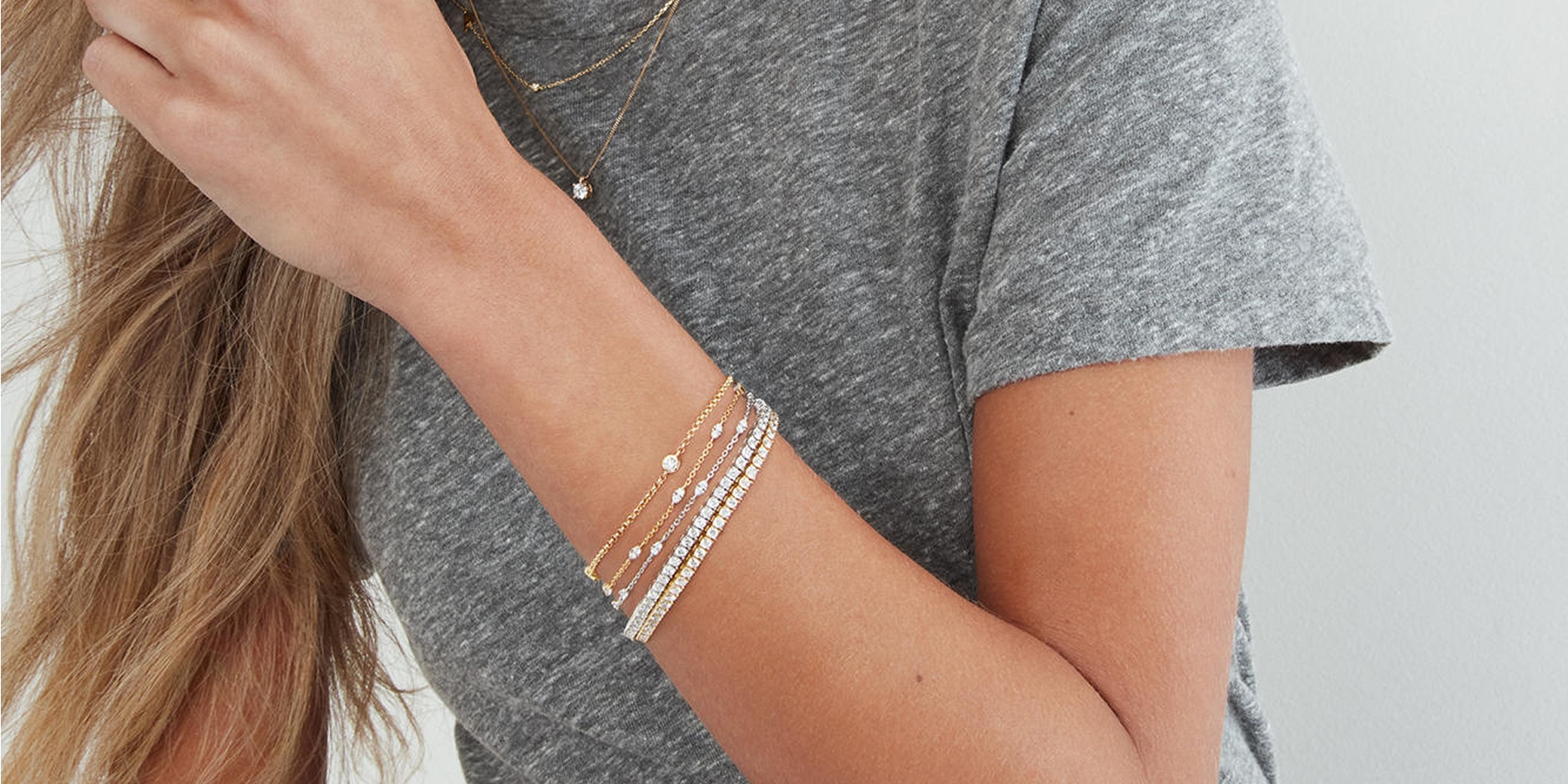 Woman wearing stacked diamond bracelets from KAY