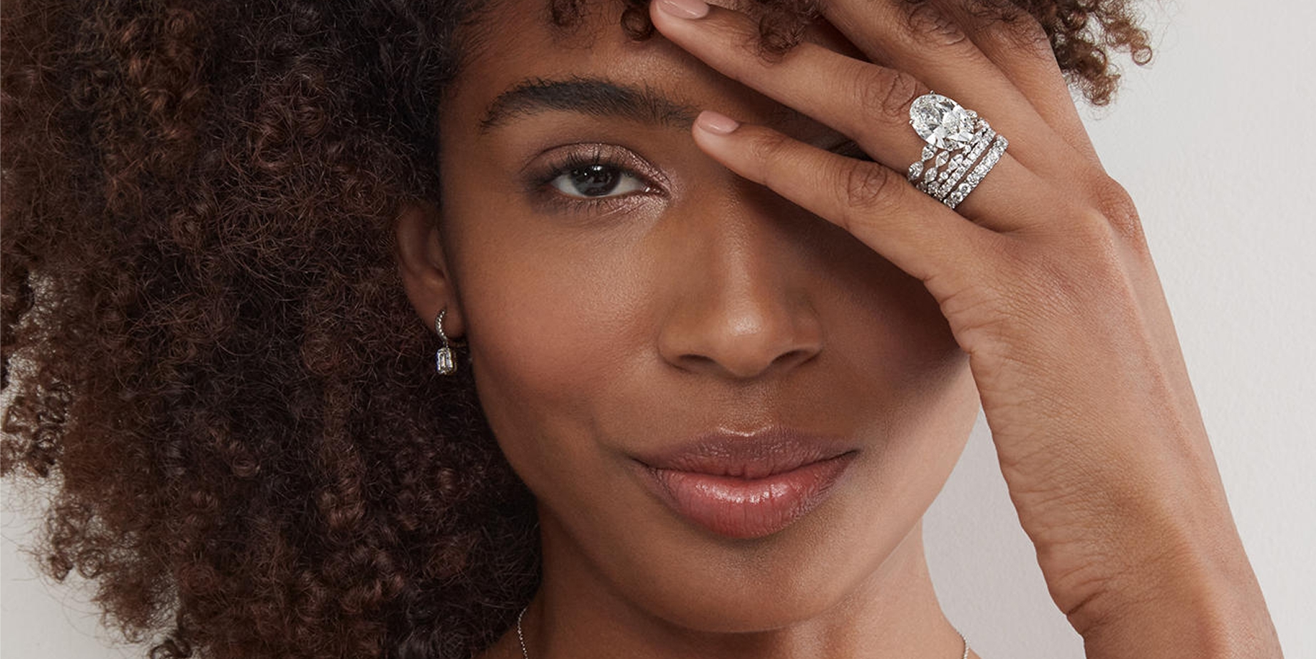 Woman wearing Neil Lane engagement ring and bands from KAY