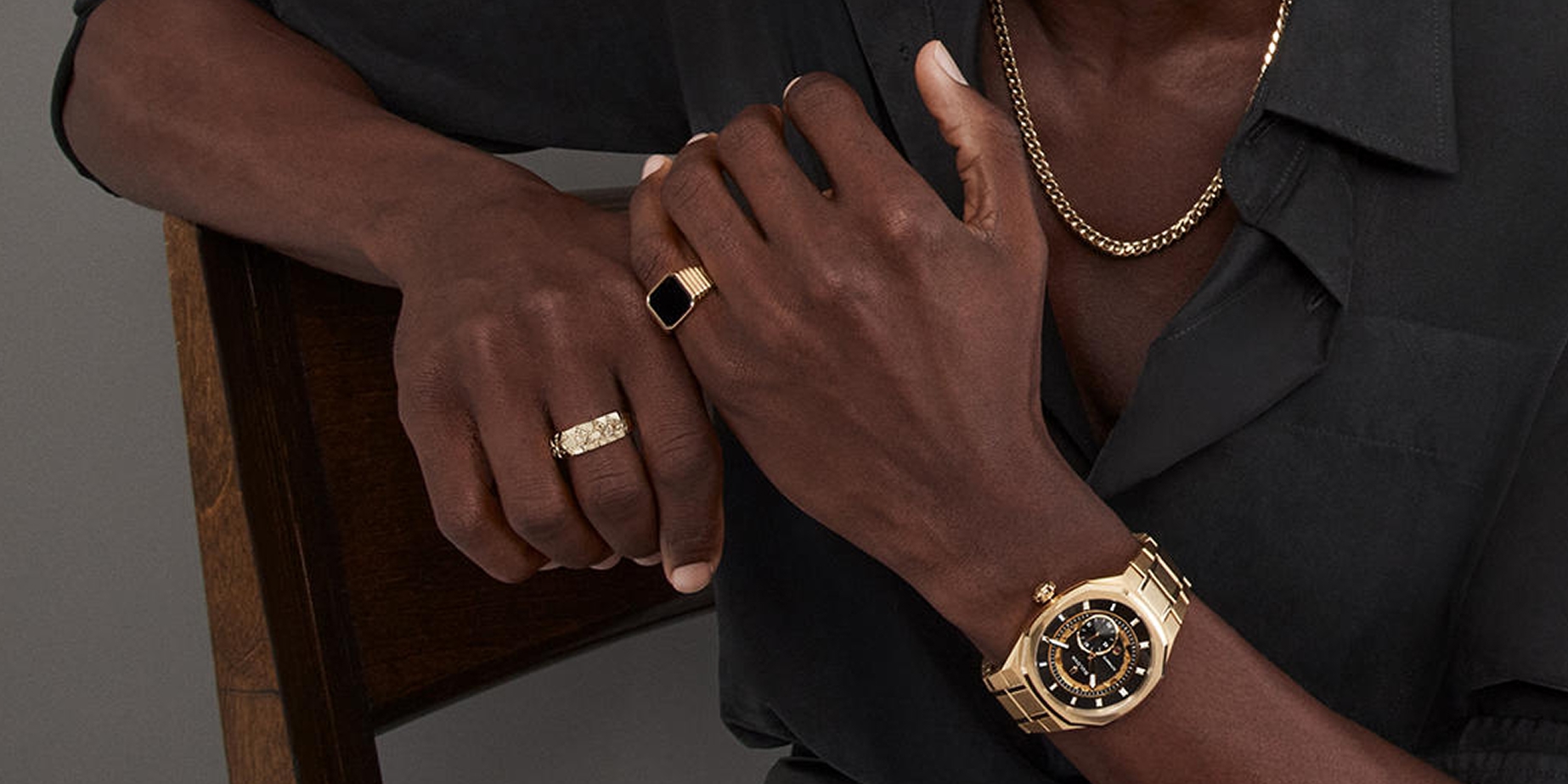 Man wearing gold and black men's rings from KAY