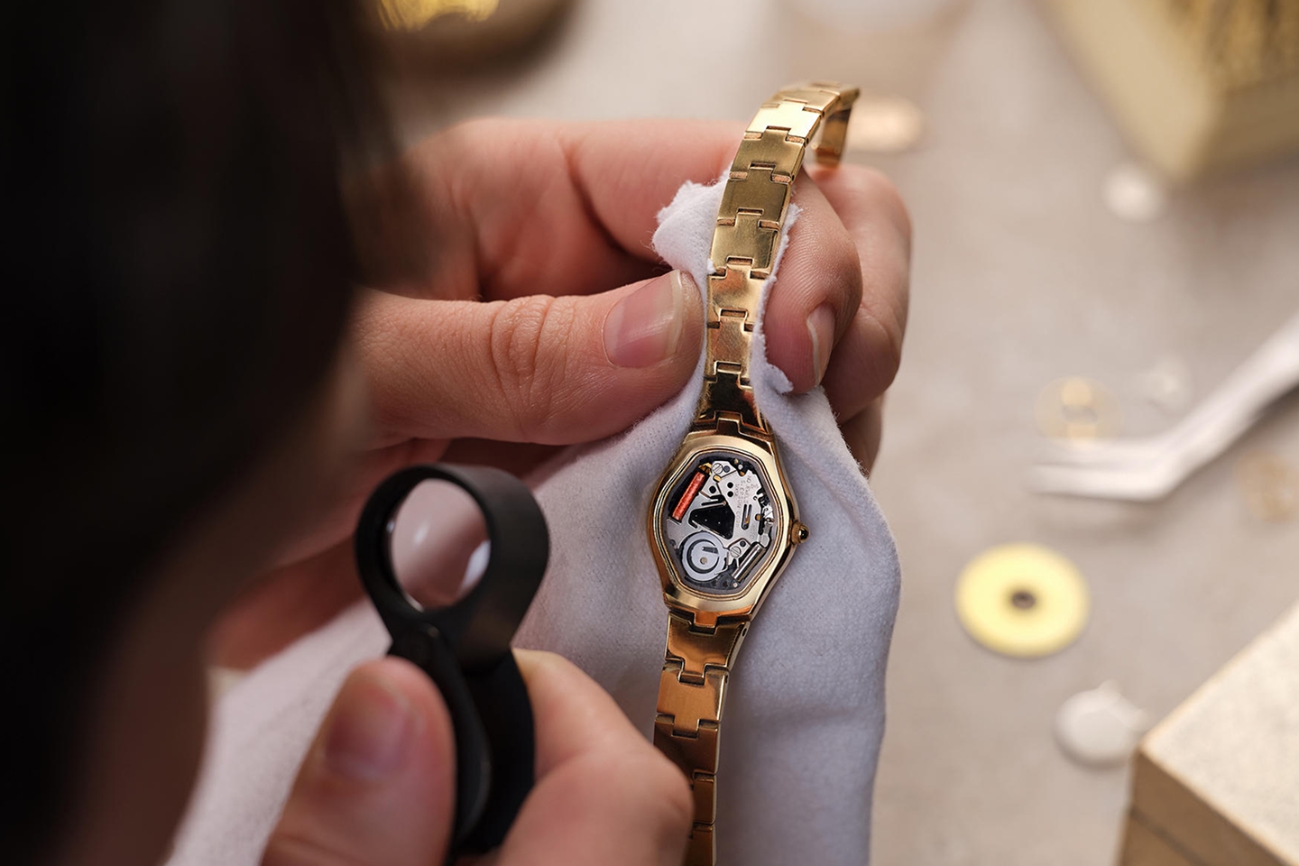 Jeweler inspecting exposed watch gears