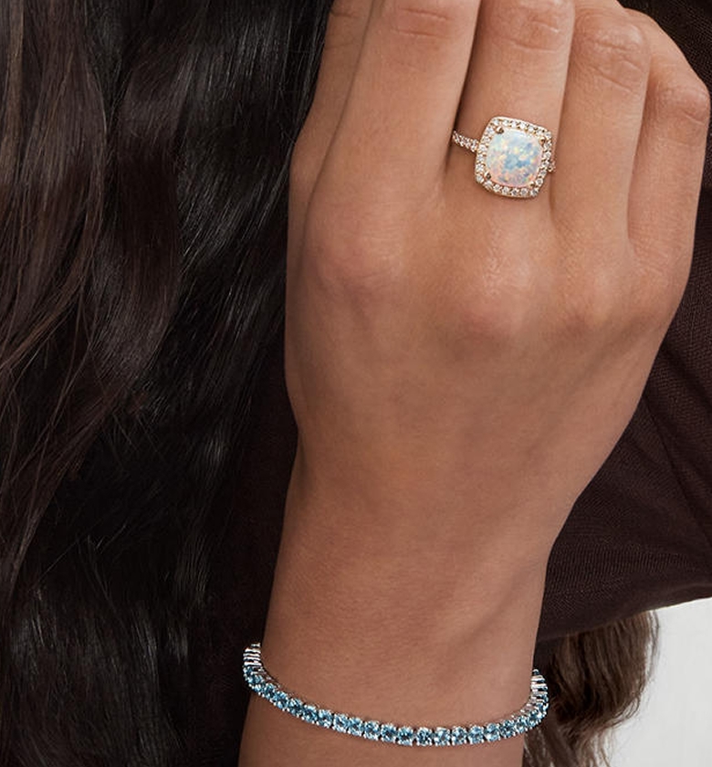 A woman showing off her opal and diamond ring from KAY.