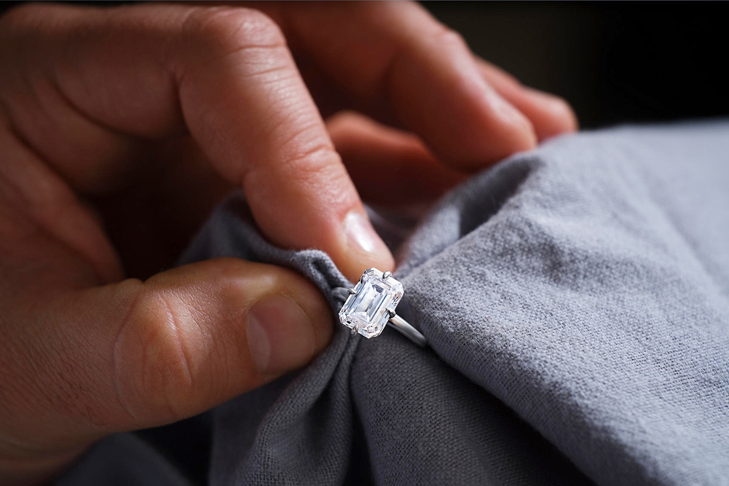 Man cleaning diamond ring with cloth