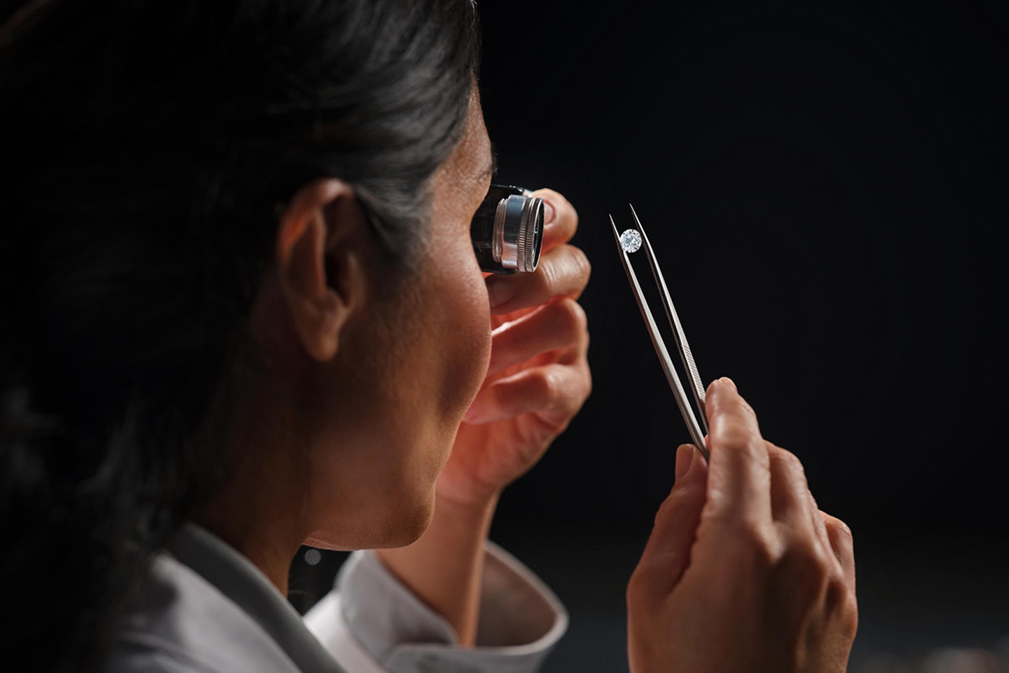 Jeweler carefully inspecting loose diamond