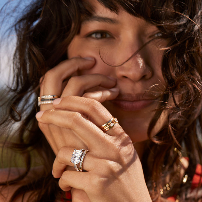 Woman wearing a variety of stackable rings. Shop Stackable rings.