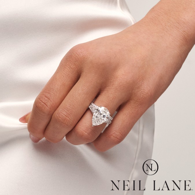Image of bride wearing pear cut diamond Neil Lane ring.