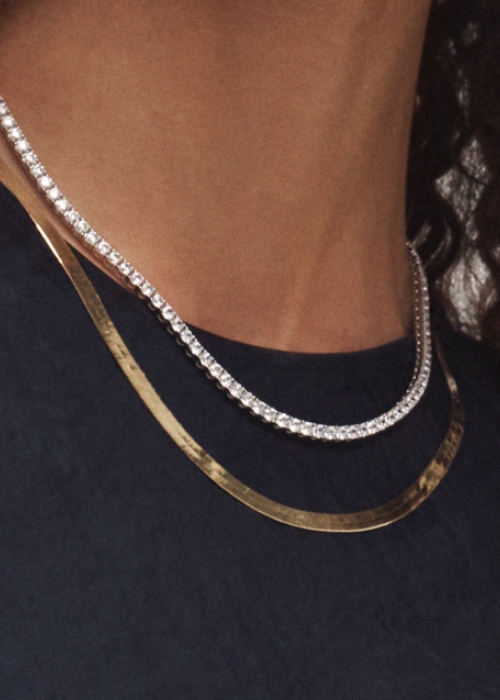 Tennis necklace layered with gold chain