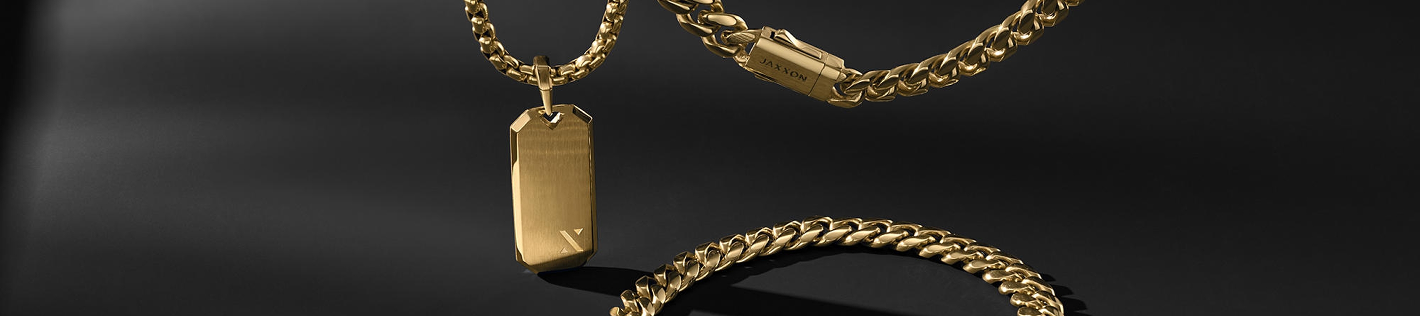 Three Jaxxon gold chains on dark gray background