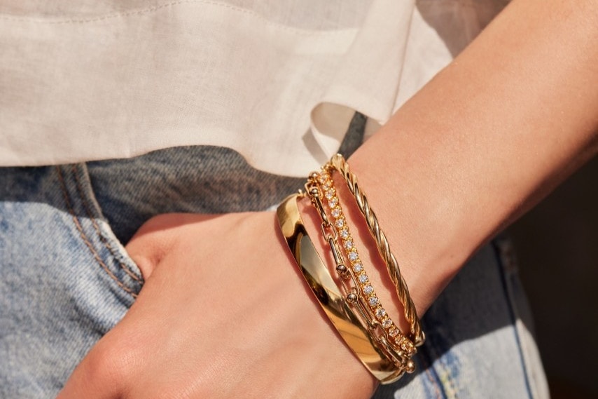 Image of woman wearing several gold bracelets