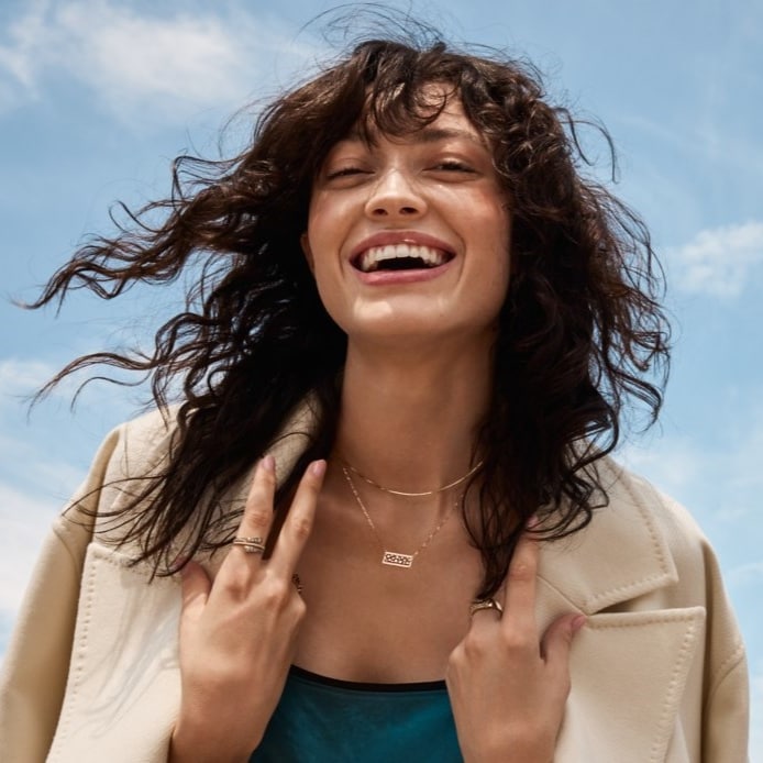 Image of smiling woman wearing several Le Vian pieces