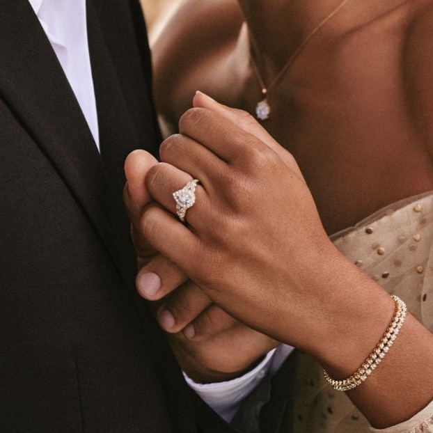 Image of couple embracing and woman wearing engagement ring