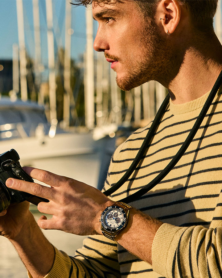 Man wearing watch taking photos at a marina