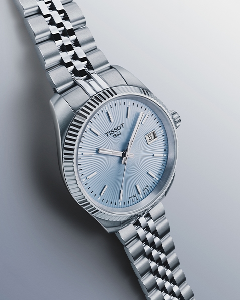 Tissot Ballade watch with light blue watch face on gray background