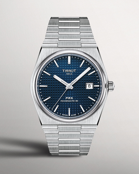 Tissot PRX watch with navy watch face on gray background