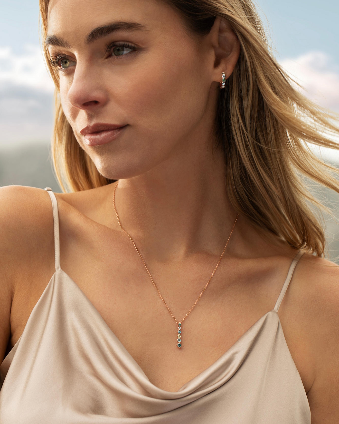 Aquamarine and diamond drop pendant necklace in rose gold paired with matching gemstone hoop earrings, elegantly styled on a model to highlight vibrant blue gemstones, delicate sparkle, and refined everyday luxury jewelry for Kay.