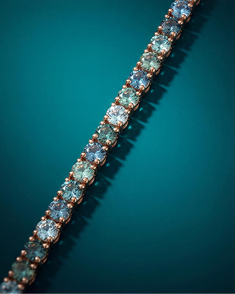 Aquamarine and blue gemstone tennis bracelet in warm gold featuring alternating round-cut stones, showcasing vibrant color contrast and elegant fine jewelry craftsmanship for Kay.