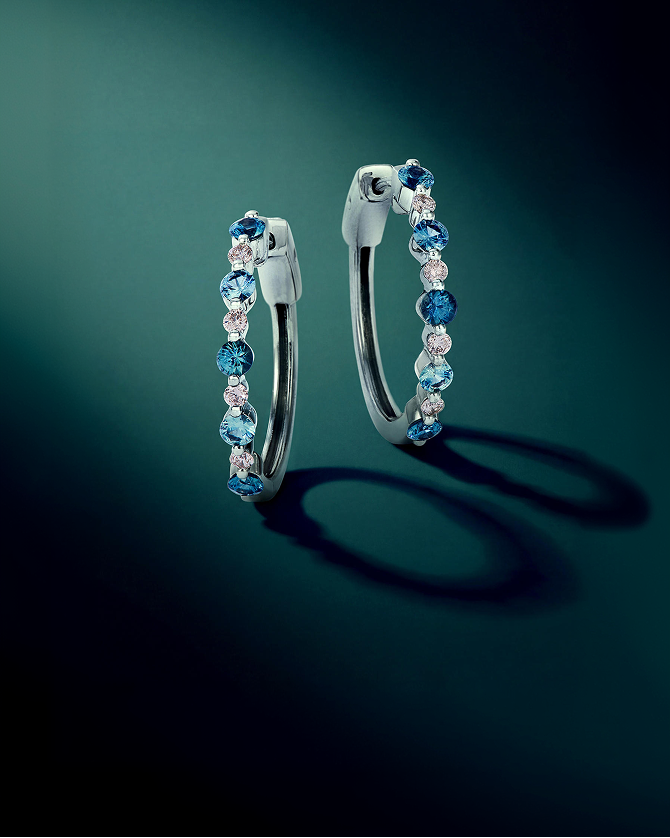 White gold hoop earrings adorned with aquamarine, blue gemstones, and diamonds, highlighting colorful brilliance, modern elegance, and fine jewelry design for Kay.