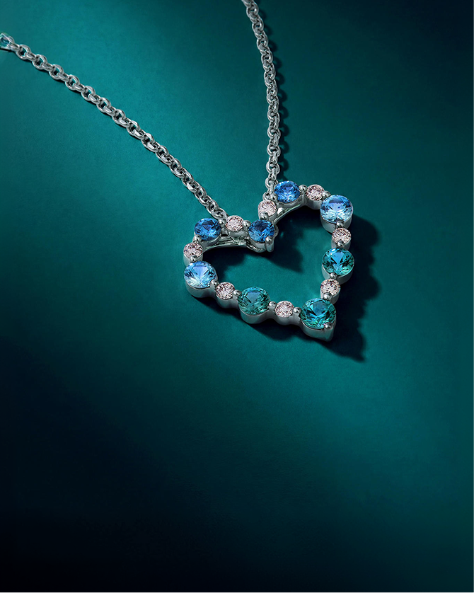 Heart-shaped pendant necklace featuring aquamarine, blue gemstones, and diamonds in white gold, creating a sparkling statement of color and romance for Kay.