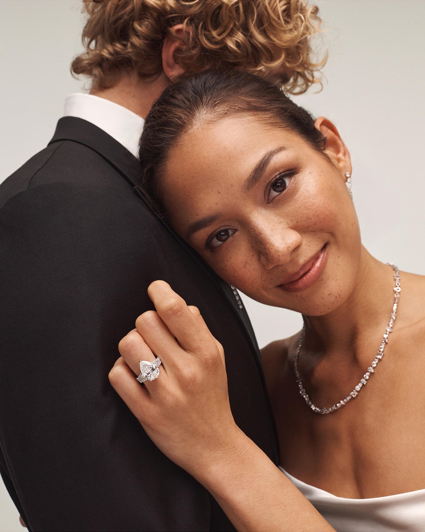 Kay Neil Lane Artistry engagement ring showcased on a model wearing a brilliant pear-shaped diamond ring, paired with a diamond necklace and earrings, highlighting designer-inspired bridal elegance and exceptional sparkle.