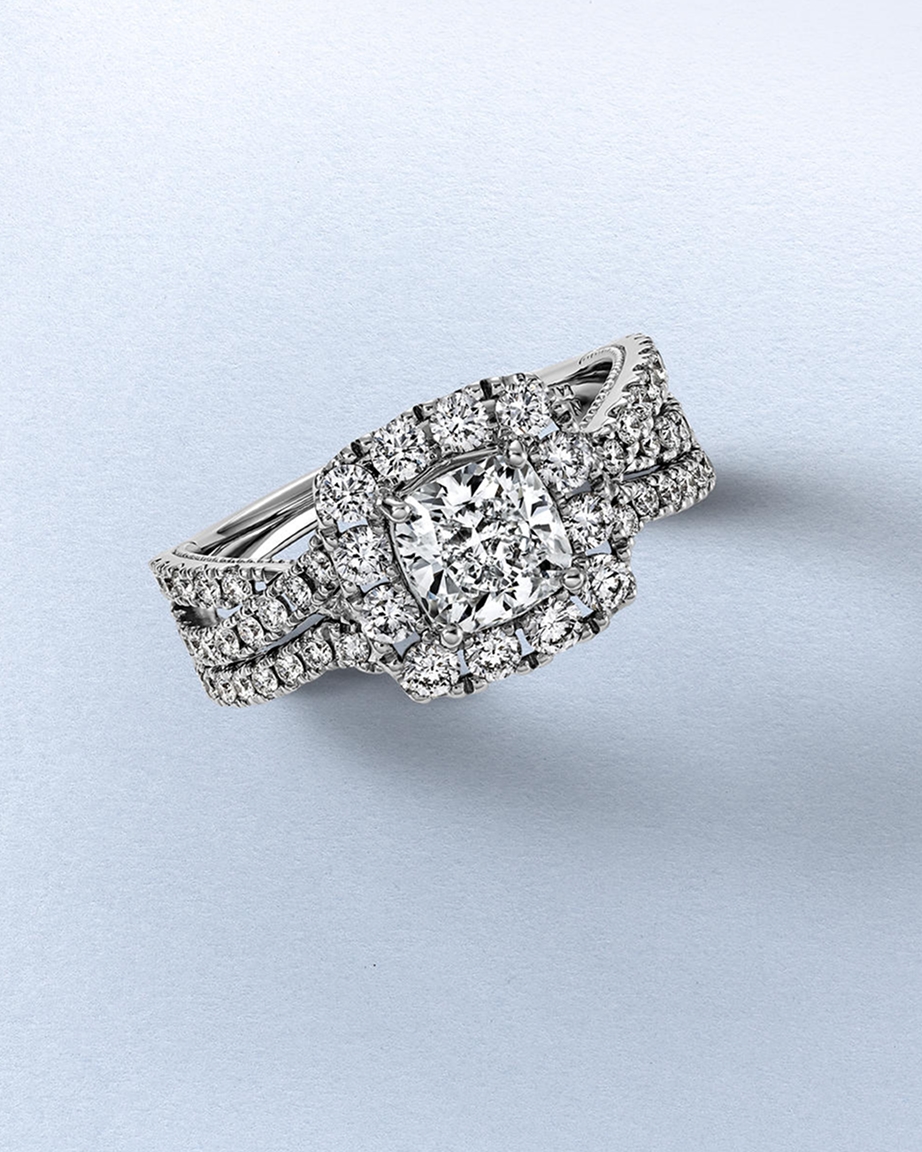 Kay Neil Lane diamond bridal set featuring a cushion-cut center diamond, halo setting, and coordinating pavé diamond bands in white gold, showcasing exceptional sparkle and bridal elegance.