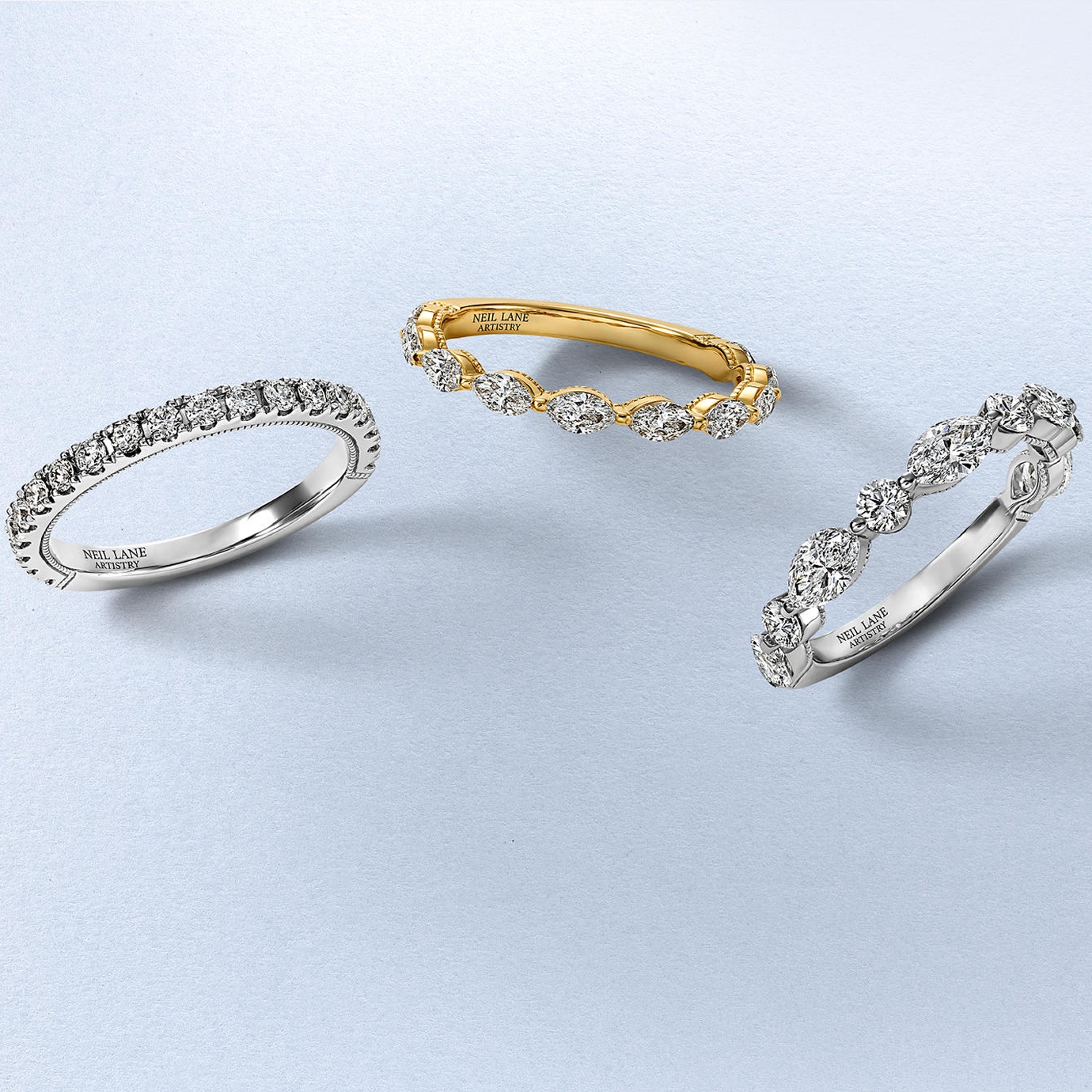 Kay Neil Lane Artistry diamond bands collection featuring white gold and yellow gold eternity-style rings with round and marquise-cut diamonds, showcasing designer craftsmanship and brilliant sparkle.
